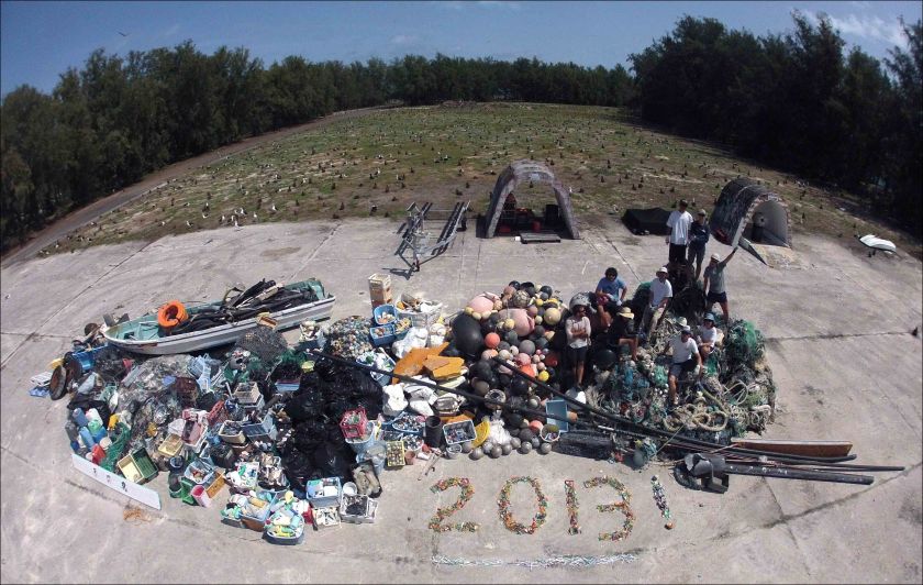 James Morioka, Kerrie Krosky, Kristen Kelly, Tomoko Acoba, Kevin O’Brien, Kerry Reardon, Edmund Coccagna, Joao Garriques, and Russell Reardon (clockwise from upper right) pose on April 18 atop the large, 13,795-kg pile of derelict fishing gear and plastic debris collected during their 21-day mission at Midway Atoll. NOAA photo by Edmund Coccagna